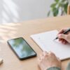 スマートフォンと無地のチェックリストを机に置き、申込前の準備を確認する様子