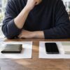財布と、スマートフォン・口座管理用ノートの二つの使い方を並べて考える様子